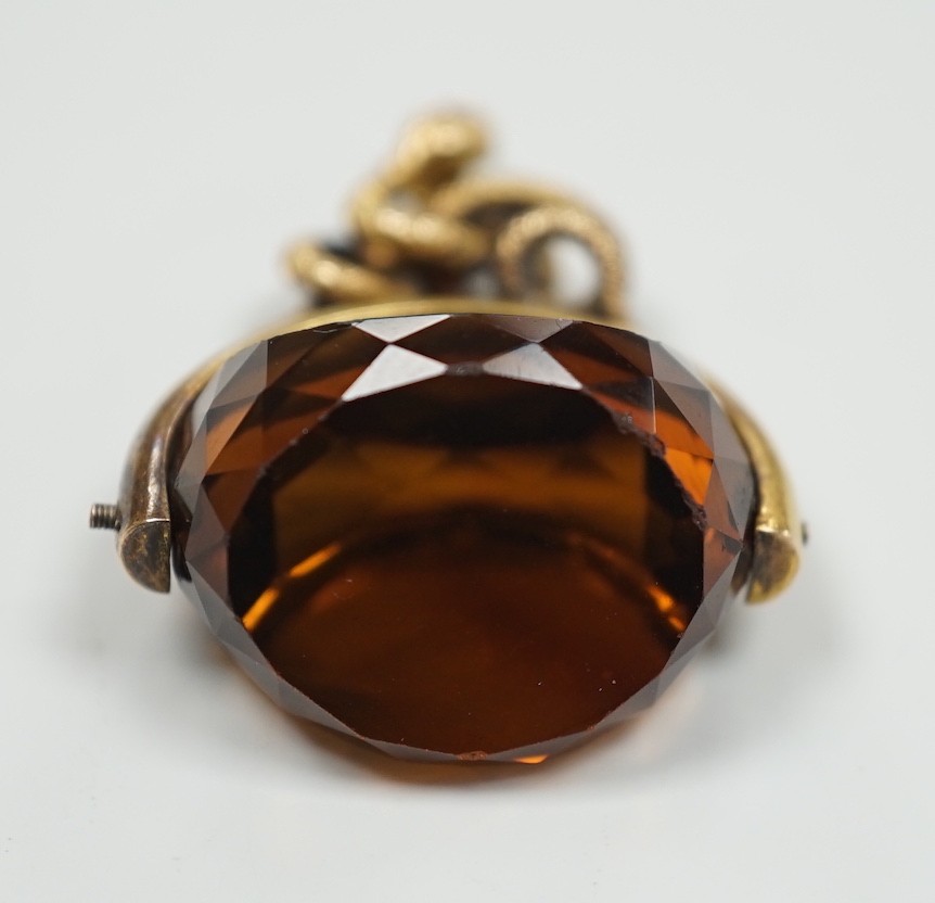 A late Victorian 15ct mounted citrine spinning fob seal, with serpent entwined bale, 34mm, gross weight 11.1 grams.